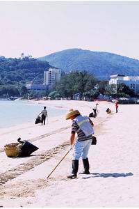Cleansing staff collects floating refuse landed on the beach 