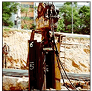 Quieter non-percussive piling with resilient pad on pile tip