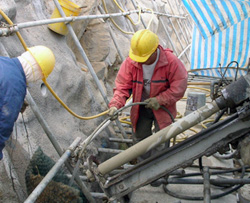 Continuous manual watering the drill bit to suppress dust emission during drilling for soil nail