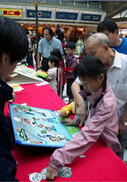 Public concentrated on playing environmental game at the booth.